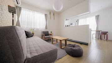 A modern living room with a grey sofa, a wooden coffee table, and a bean bag.