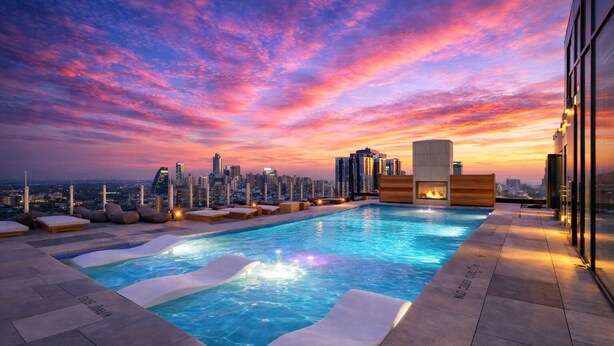 Ein Pool auf dem Dach mit Blick auf die Skyline bei Sonnenuntergang.
