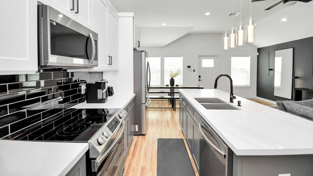 A modern kitchen with white cabinetry, stainless steel appliances, and a central island. - Modern 3 Bedroom Close To DTWN/NRG/Med Center (Houston)
