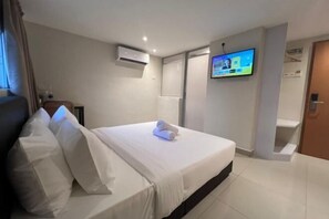 A hotel room with a bed, a TV mounted on the wall, and an air conditioning unit. - Swing & Pillows @ Kajang Selangor (Kajang)