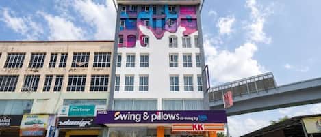 Un edificio de varios pisos con un letrero llamativo que dice 'Swing & Pillows' en la planta baja.
