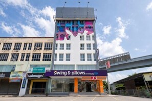 En byggnad med flera våningar, där det på bottenvåningen finns en väl synlig skylt med texten ”Swing & Pillows”.