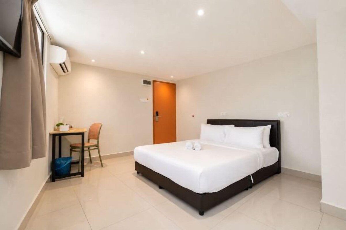 Una camera d'albergo con un letto, una scrivania, una sedia e una porta.