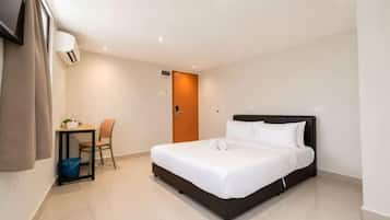 Una habitación de hotel con cama, escritorio, silla y puerta.