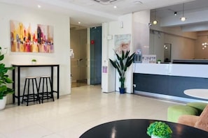A hotel lobby with a reception desk, seating area, and a large potted plant. - Swing & Pillows @ Kajang Selangor (Kajang)