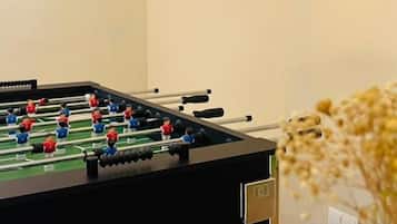 Una mesa de fútbolín en una habitación con una pared lisa y un enchufe.