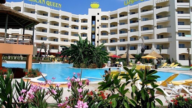 A hotel with multiple balconies, a swimming pool, and outdoor seating areas. - African Queen  (Hammamet)
