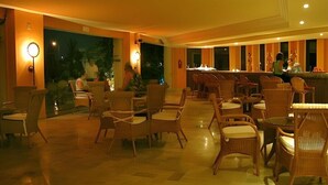 A spacious indoor area with wicker furniture and a bar counter. - African Queen  (Hammamet)
