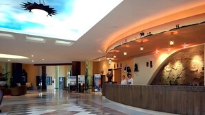 A spacious lobby with a checkered floor, a reception desk, and a ceiling with a sun-like design. - African Queen  (Hammamet)