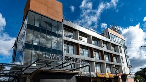 Un edificio moderno con el letrero "AV MILETS SUITES", que indica que es un hotel.