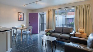 Eine moderne Wohnung mit Essbereich, einer Couch und einem kleinen Tisch.