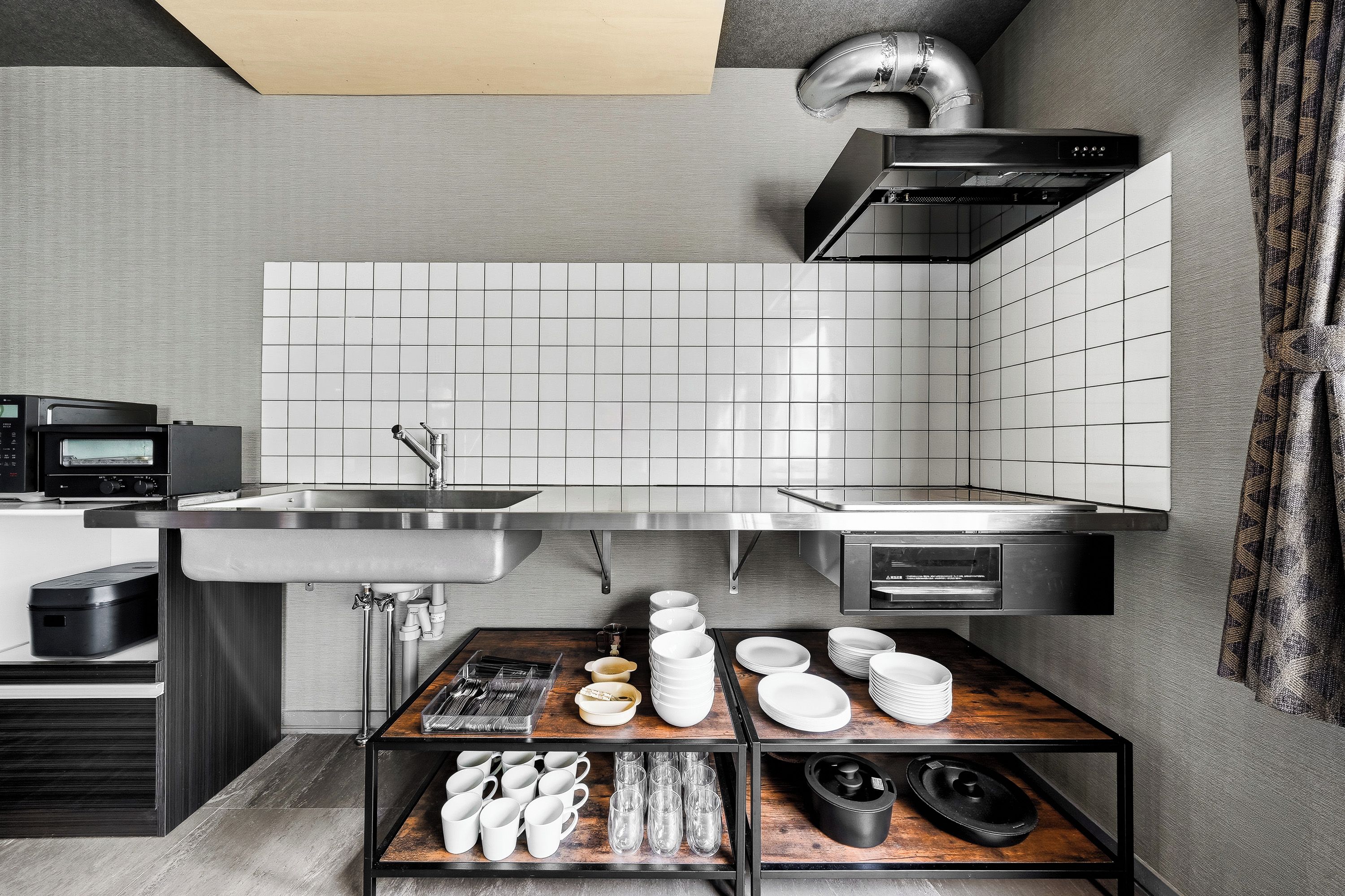 A modern kitchen with a built-in microwave, stainless steel sink, and a range hood.