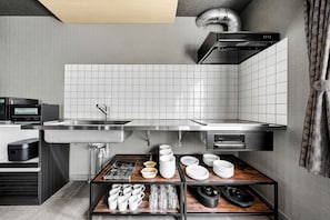 A modern kitchen with a built-in microwave, stainless steel sink, and a range hood.