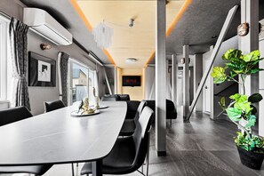 A modern conference room with a long table, chairs, and a television screen displaying 'NETFLIX'.