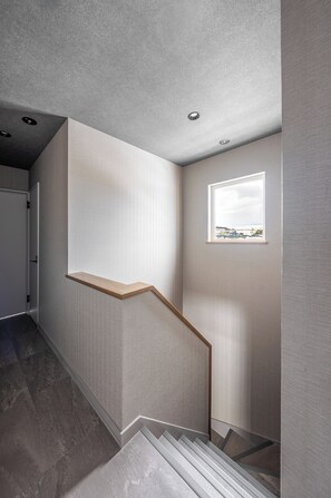 A modern staircase with a wooden handrail and a small window at the top. - THE LAVENRIDGE (Nakafurano)