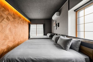 A modern hotel room with a large bed, a window with a view, and a wooden accent wall.