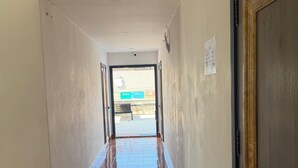 A hallway with a tiled floor leading to a door marked R.203. - VangVieng Boutique Hotel (Vang Vieng)