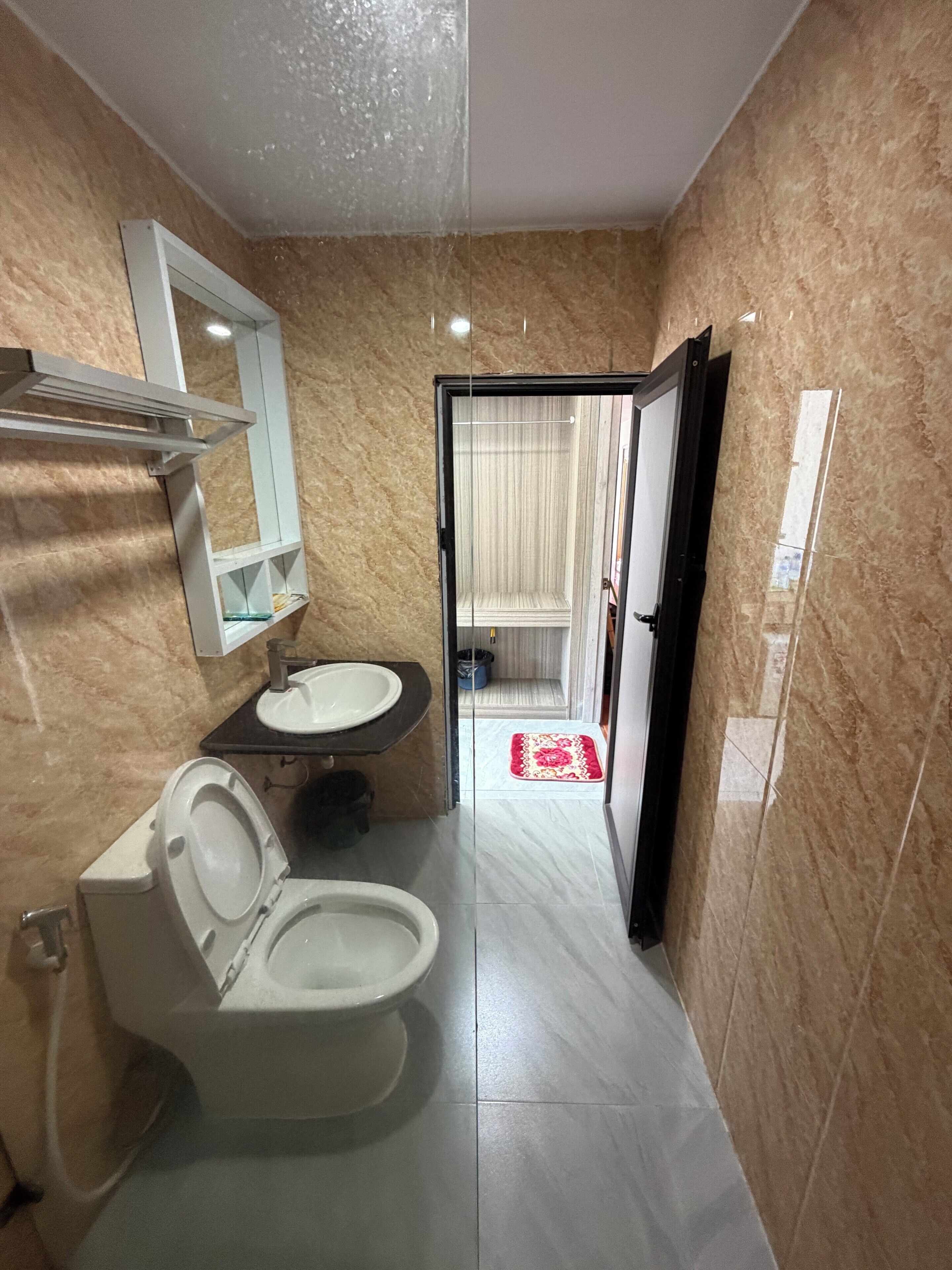 Un baño con inodoro, lavabo y espejo.