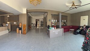 A modern lobby with a massage station, seating area, and a Christmas tree. - VangVieng Boutique Hotel (Vang Vieng)