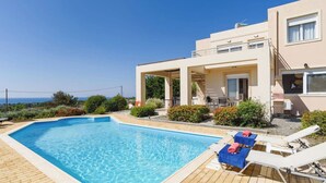 A swimming pool with lounge chairs and a covered patio area. - Villa Phoebe Gennadi (2W76+JJ South Rhodes, Greece)