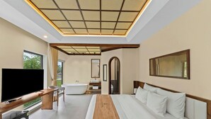 A modern hotel room with a large bed, a flat-screen TV, a wooden bench, a bathtub, and a large window. - Cuc Phuong Tropical Retreat (Phu Long)