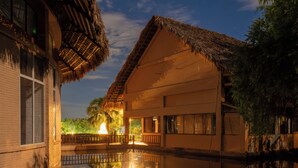 A resort with thatched-roof buildings, a pool, and a night sky. - Cuc Phuong Tropical Retreat (Phu Long)
