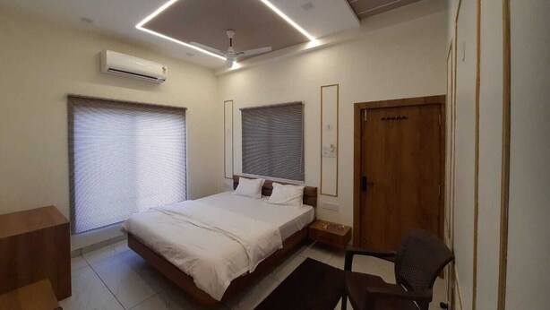 Une chambre à coucher moderne avec un lit, des tables de chevet, un bureau et une chaise.