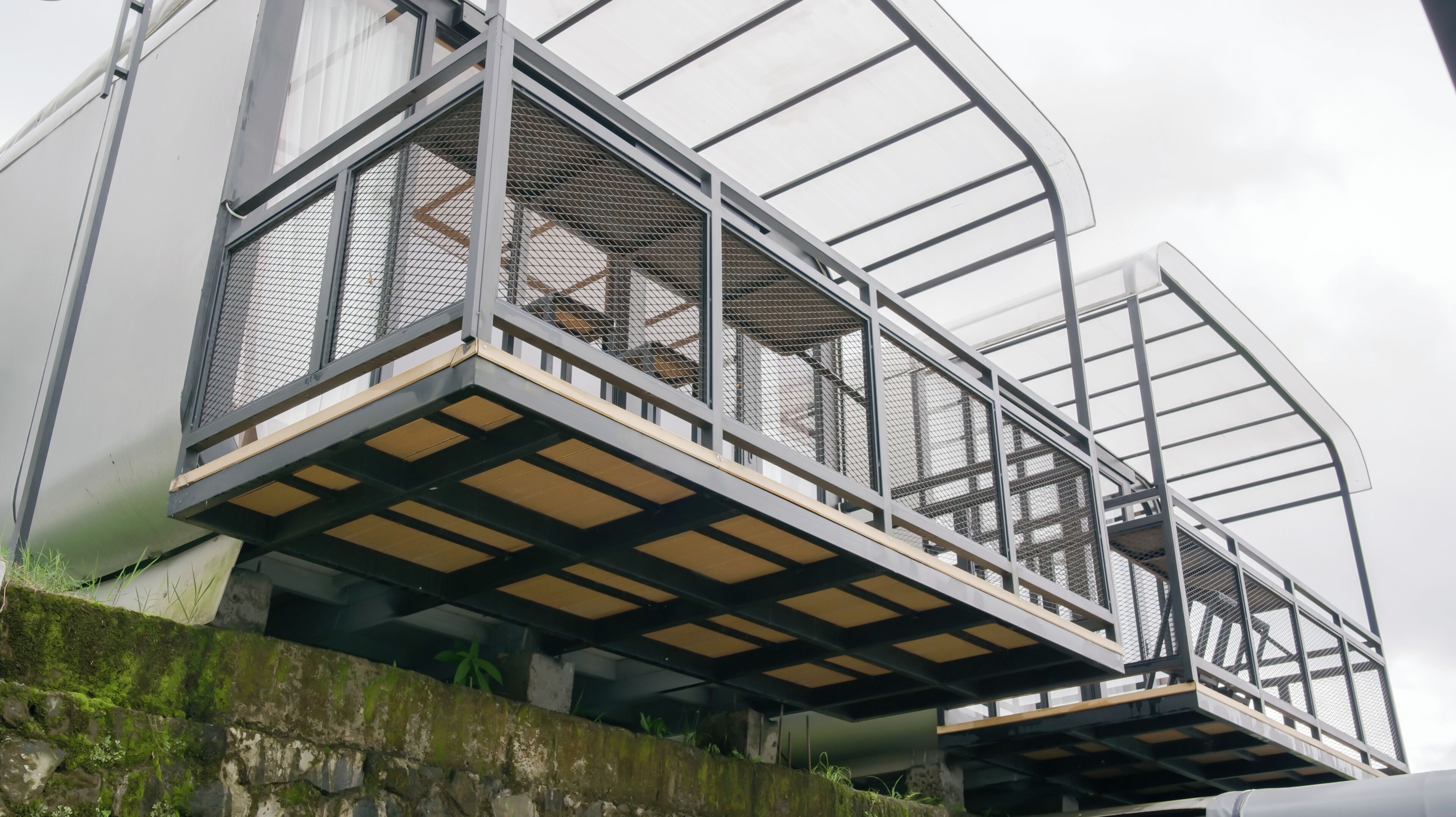 A modern architectural structure with a metal framework and glass panels.