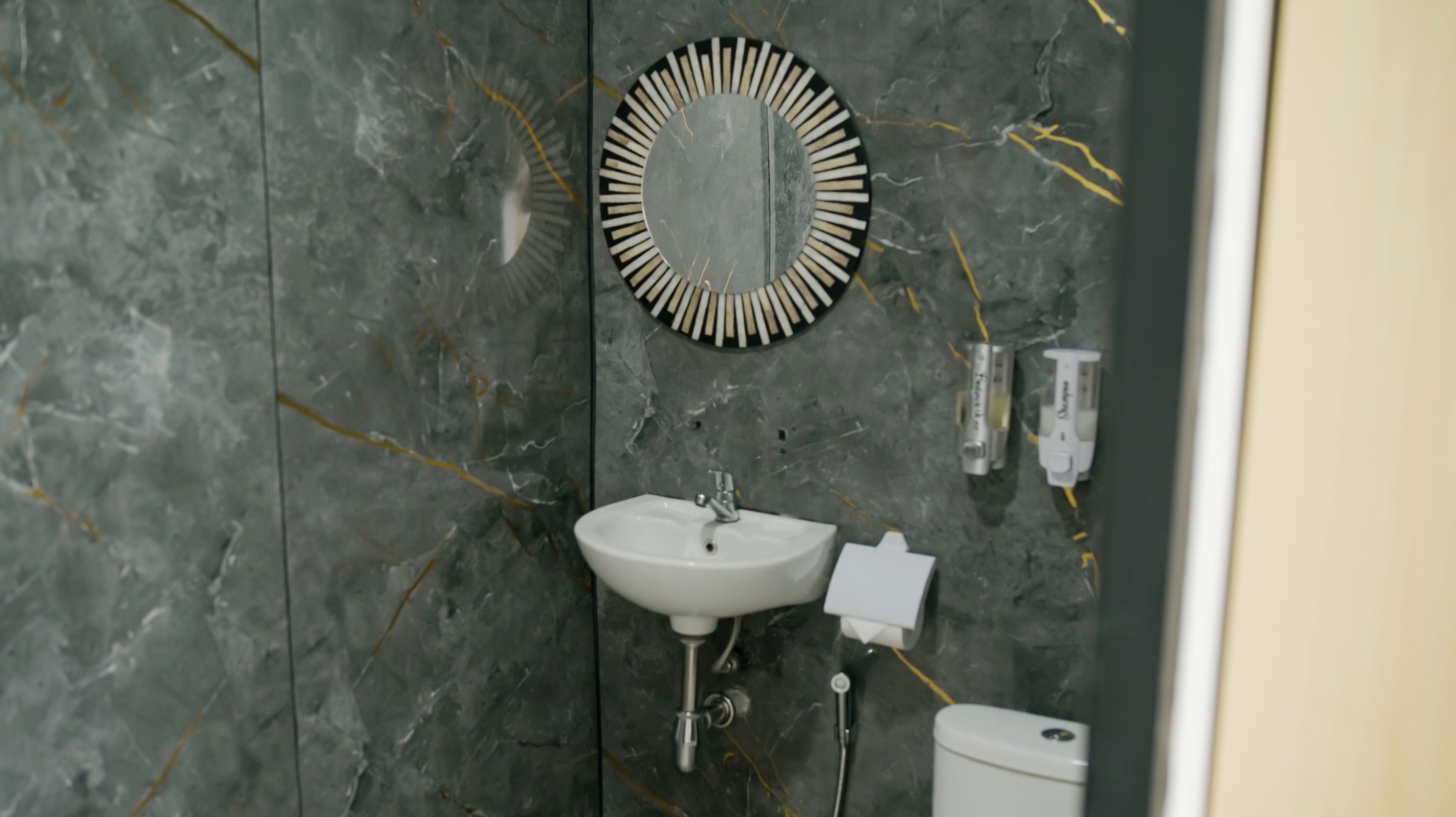 Un baño con lavamanos, espejo e inodoro.