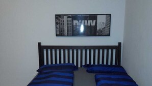 A double bed with blue and black striped bedding and two yellow pillows. - Chic 1BR Flat in Heart of Vienna (Vienna)
