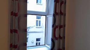 A room with a window, a radiator, and a blue sofa. - Chic 1BR Flat in Heart of Vienna (Vienna)