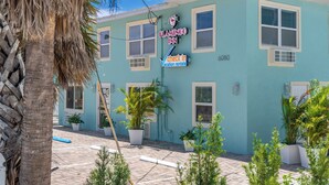 En bygning med et skilt, der viser 'FLAMINGO INN' og 'check ind ferielejligheder'.