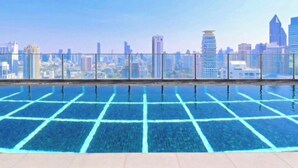 Una piscina a sfioro sul tetto con vista sullo skyline cittadino.
