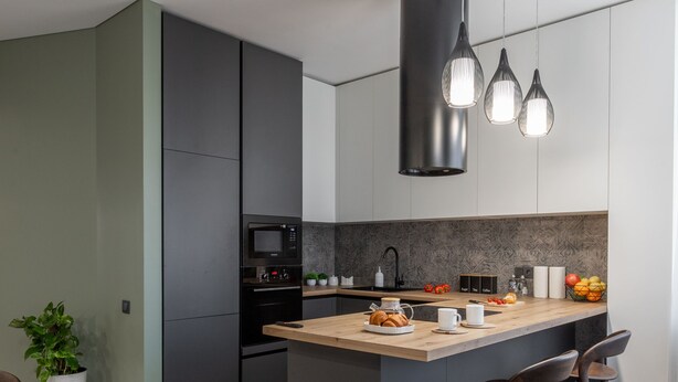 A modern kitchen with a central island, dark cabinetry, and pendant lighting. - Luxury apart with a view Victory Square (Minsk)