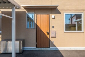 A building with a wooden door, a window, and a mailbox. - SERENE TERRACE (Asahikawa)
