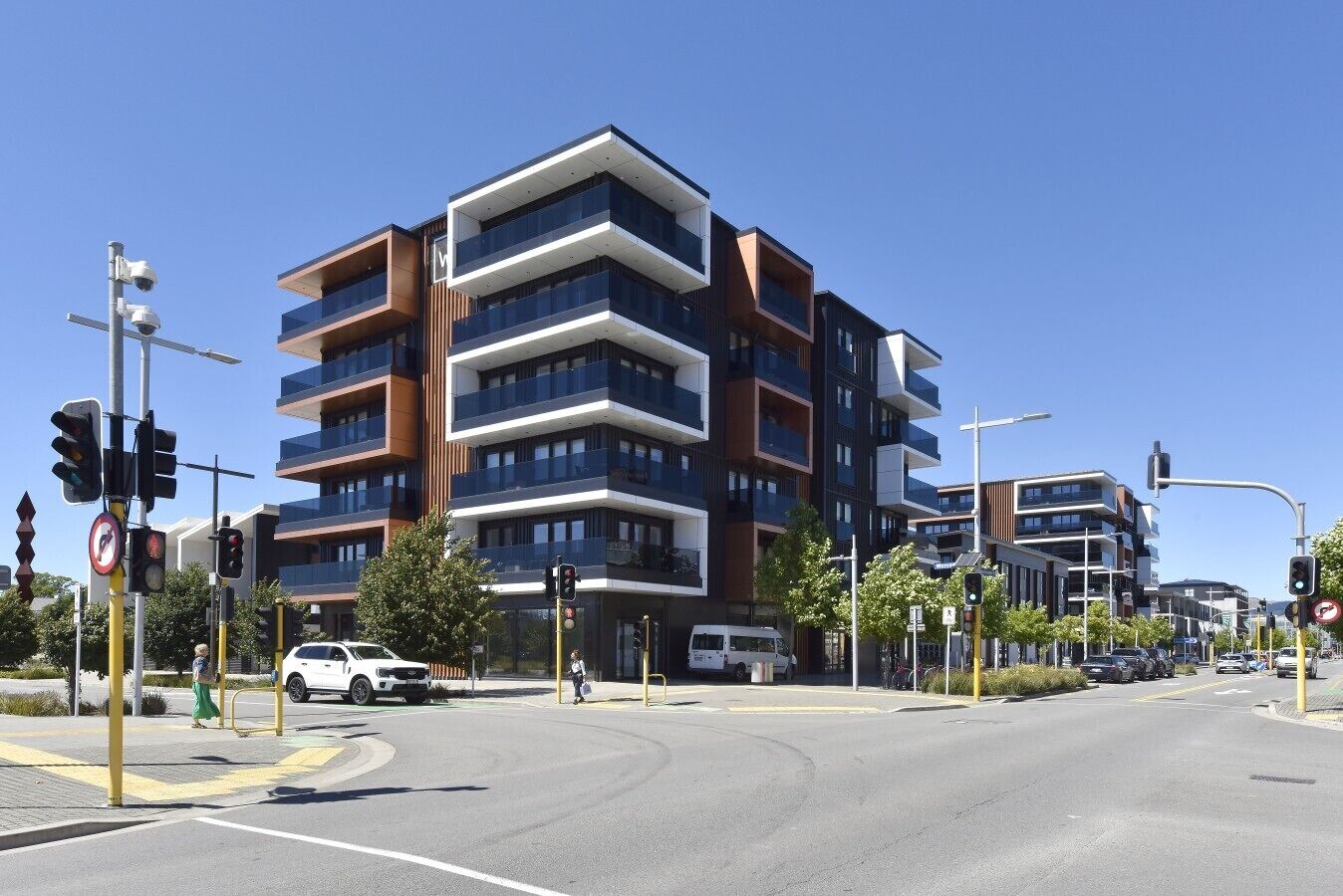 A multi-story building with a modern architectural design, featuring balconies and large windows.
