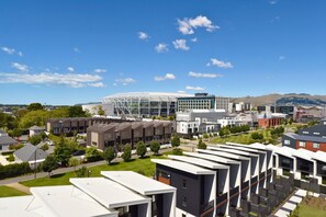 A modern building complex with multiple residential units, a large glass structure, and surrounding greenery.