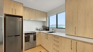 Una cocina moderna con armarios de madera, electrodomésticos de acero inoxidable y un amplio ventanal con vistas.