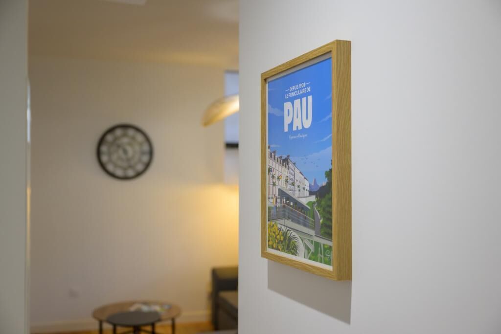 A framed poster on a wall, a clock, and a small round table.