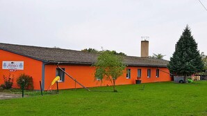 A building with an orange facade, a chimney, and a green lawn.