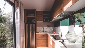 A modern kitchen with wooden cabinets, a stainless steel refrigerator, and a marble countertop. - Two-Bedroom Retreat in the Heart of Kempen (Ravels)