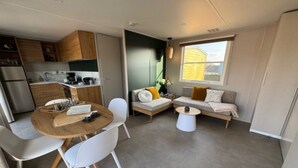A compact living space with a kitchenette, a dining area, and a seating area with a sofa and a coffee table. - Two-Bedroom Retreat in the Heart of Kempen (Ravels)