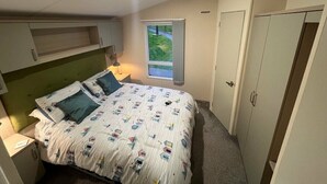 A bedroom with a bed, a window, a wardrobe, and a nightstand. - Waterside, Paignton - Holiday Accommodation 19143 (Paignton)