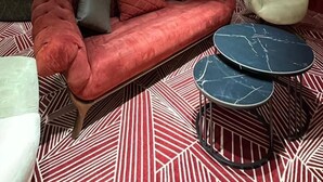 A modern living room with a red sofa, a white armchair, and a black coffee table. - Avenue Nizami Hotel (Baku)