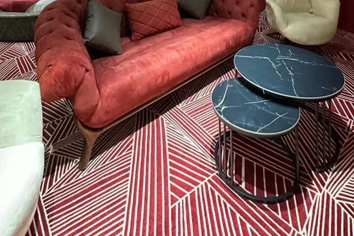 Un soggiorno moderno con un divano rosso, una poltrona bianca e un tavolino da caffè nero.