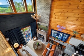 Ein modernes Interieur mit Kamin, Holzwänden, einem Essbereich und Blick ins Freie.