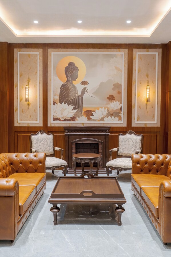 A room with a central coffee table, two armchairs, a sofa, a fireplace, and wall-mounted sconces. - Soni Arena hotel (Una)