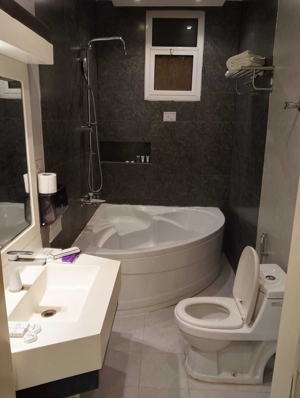 Et moderne badeværelse med badekar, toilet og vask.
