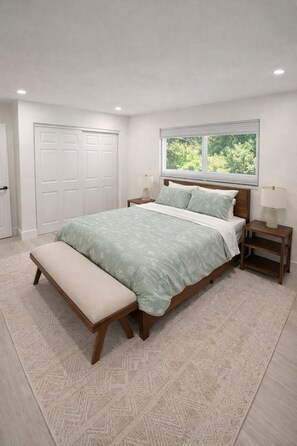 A bedroom with a bed, bench, nightstands, and a window with a view of greenery. - Sunny Oasis Near the Beach – 4BR/3BA Pool Home (Boynton Beach)