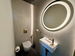 Een douche, een haardroger, een bidet, handdoeken